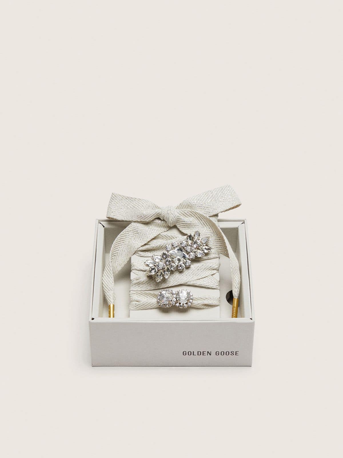 Skins "Sparkling" cream and silver herringbone laces embellished with two charms