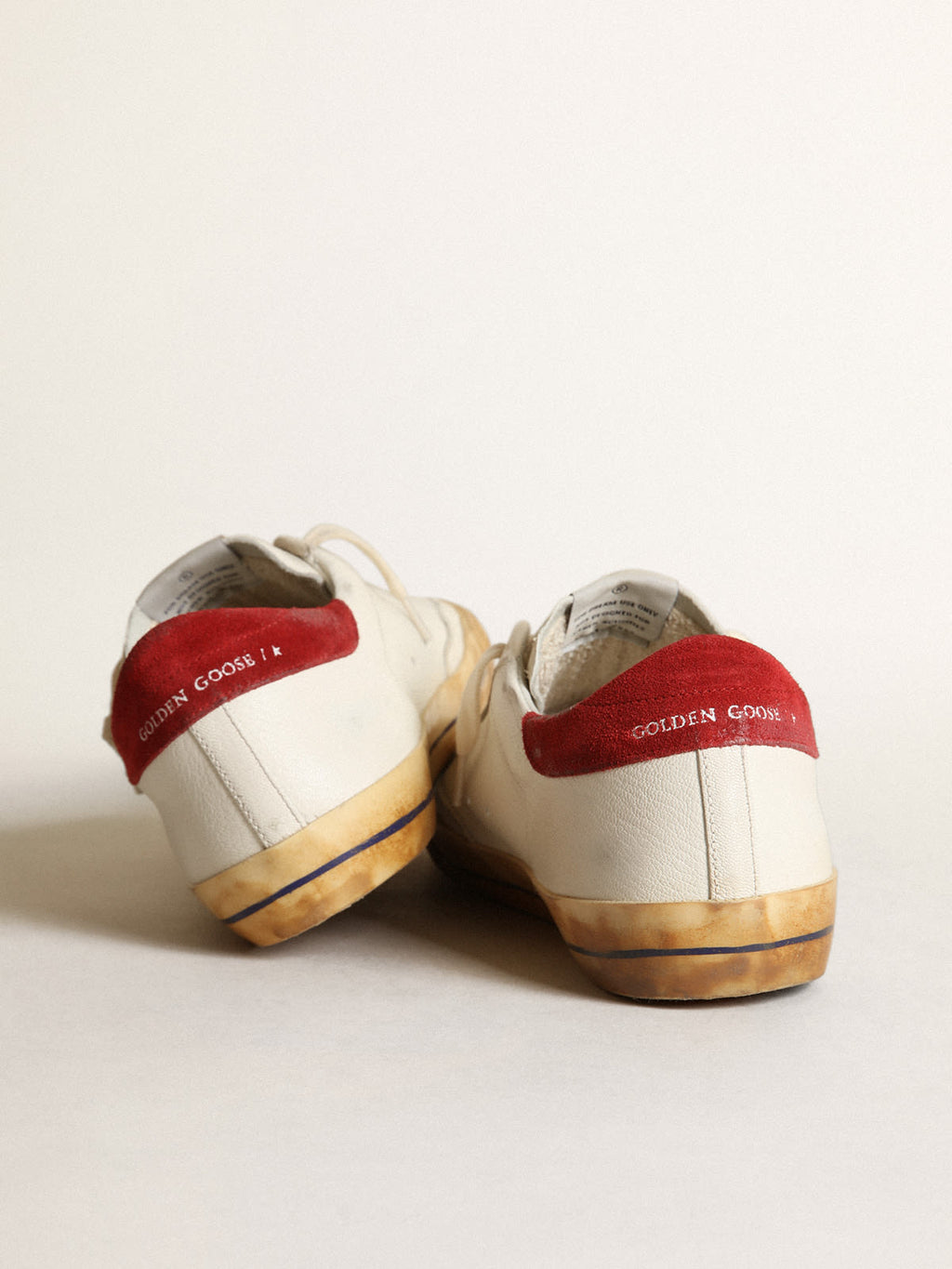 Sneaker Super-Star con stella in pelle laminata color argento e talloncino in suede rosso