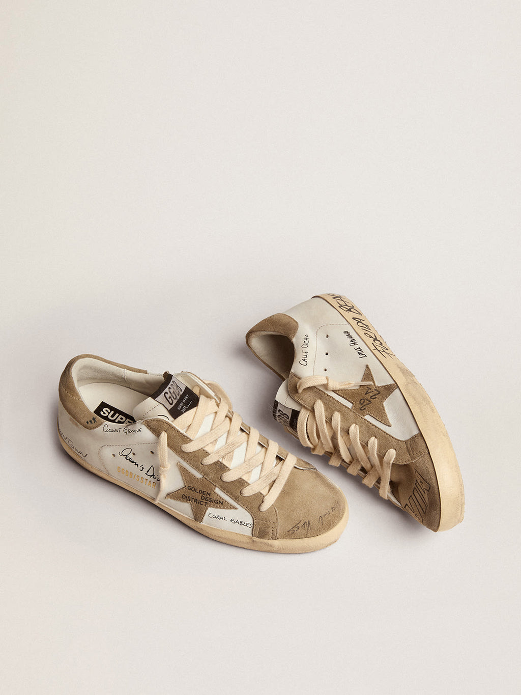 Sneaker Super-Star in pelle bianca con inserti in suede color tortora e scritte nere all-over
