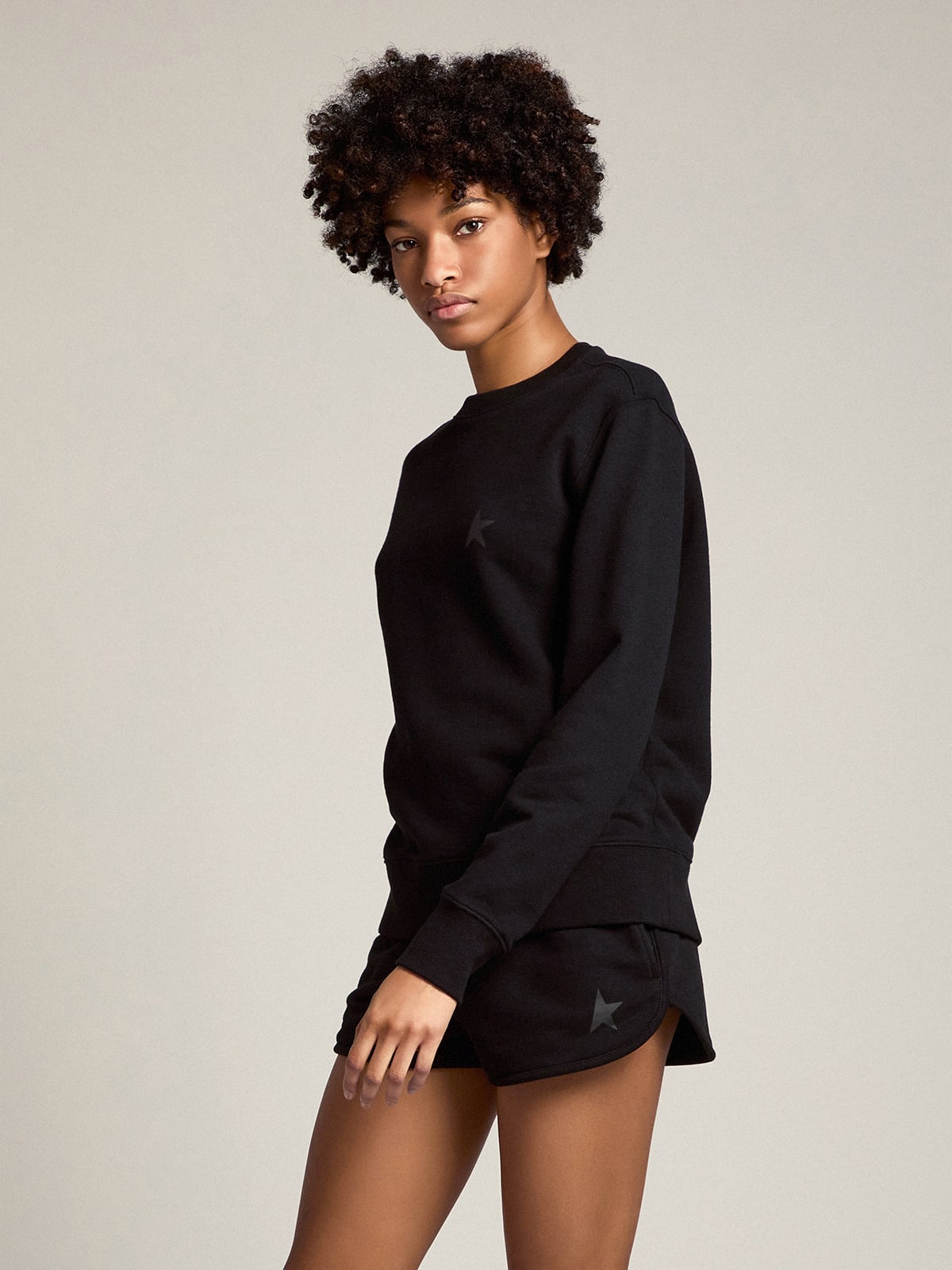 Pantaloncini di colore nero con stella ton sur ton sul davanti