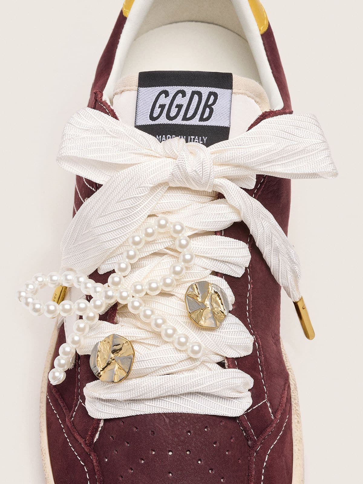 Skins "Sparkling" cream striped laces embellished with beaded charm and golden charm