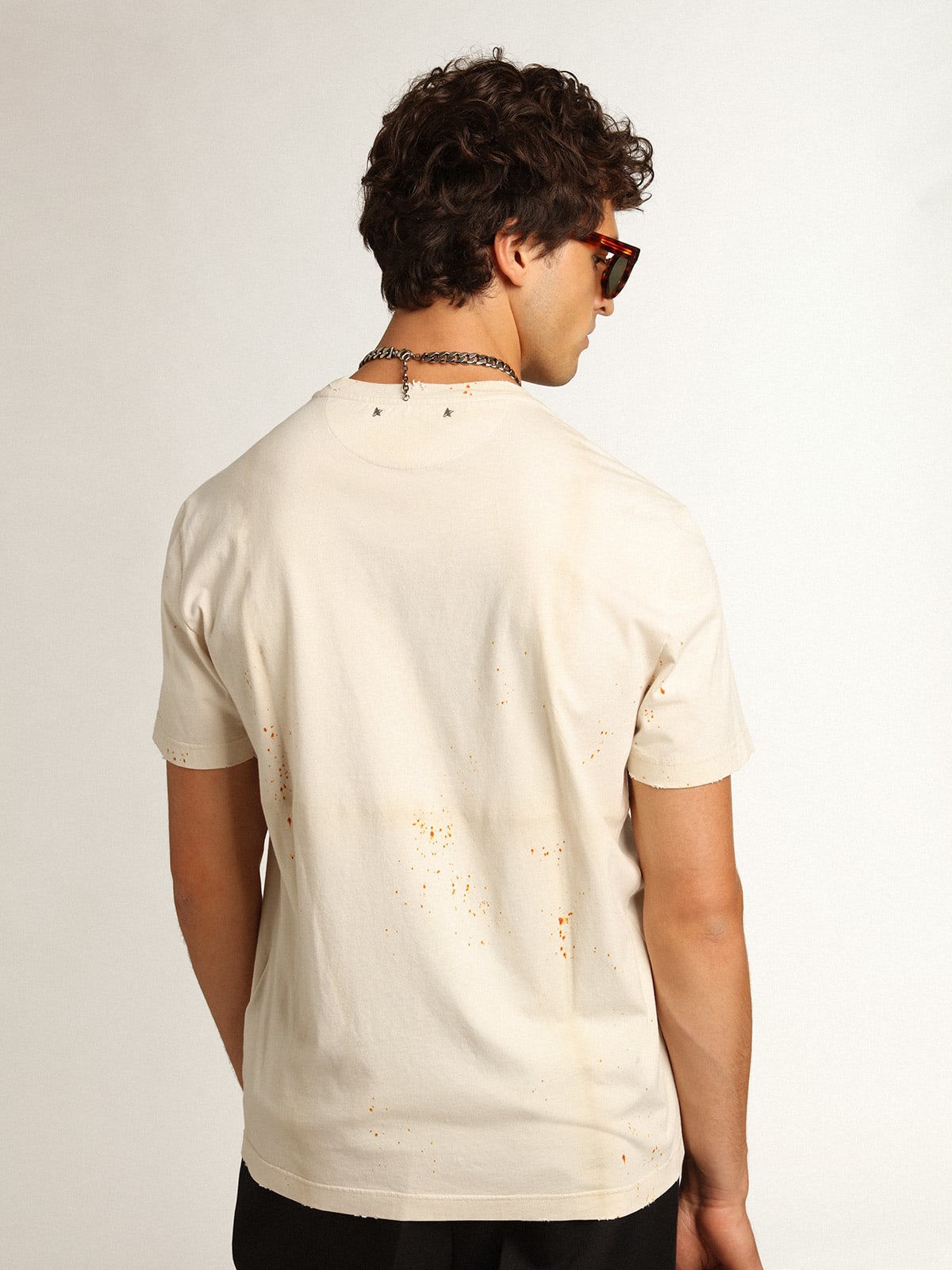 T-shirt Collezione Journey di colore bone white dall'effetto capo piegato con scritta Golden e spruzzature color ruggine