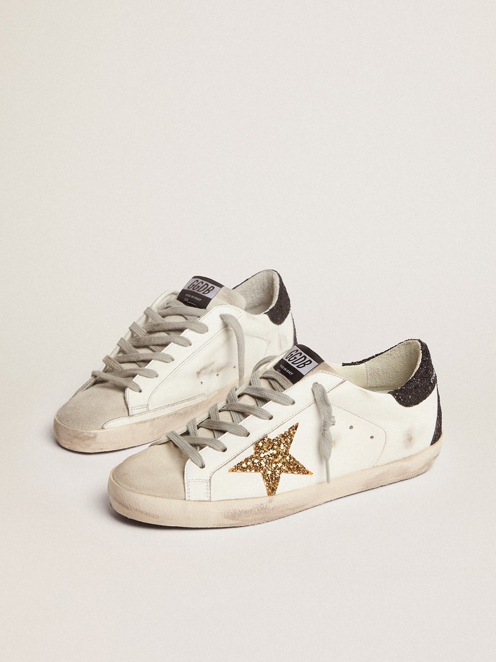 Sneakers Super-Star con stella dorata e talloncino nero in glitter