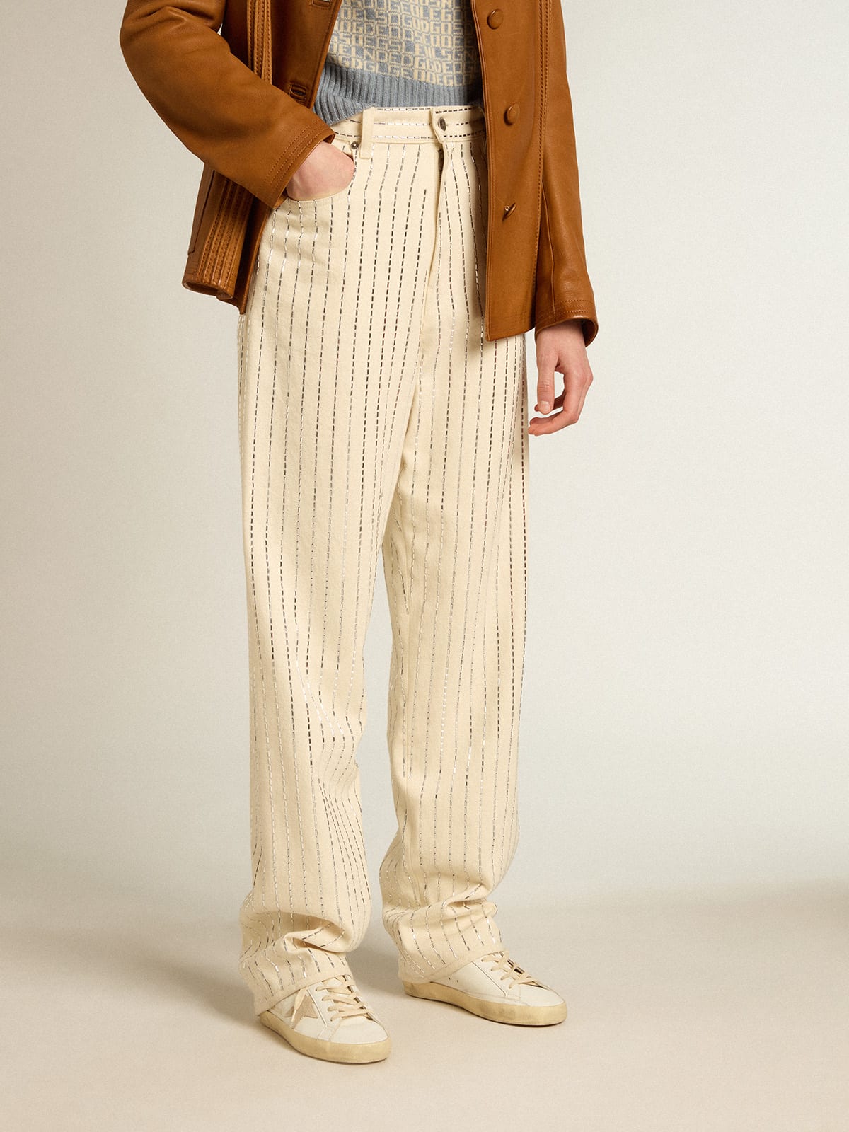 Pantalone di colore bianco con borchie a baguette applicate