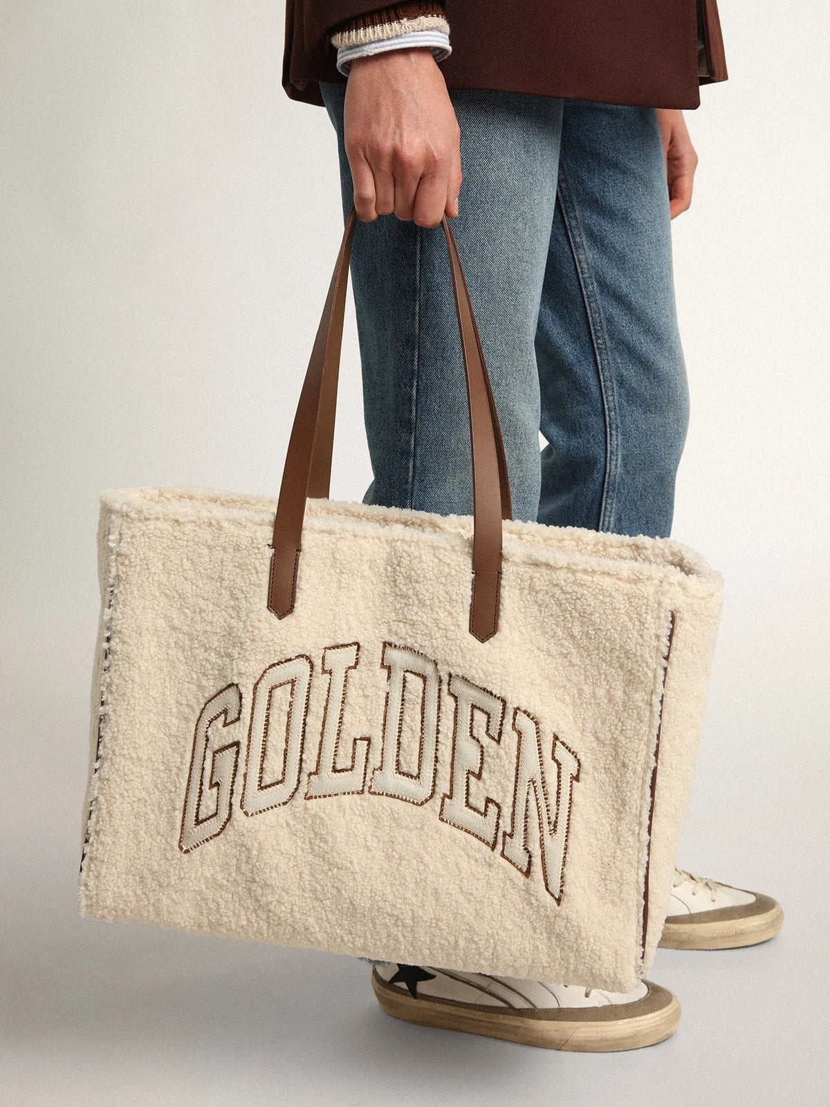 Borsa California Bag East-West in eco-pelliccia di colore bianco con scritta Golden e manici a contrasto
