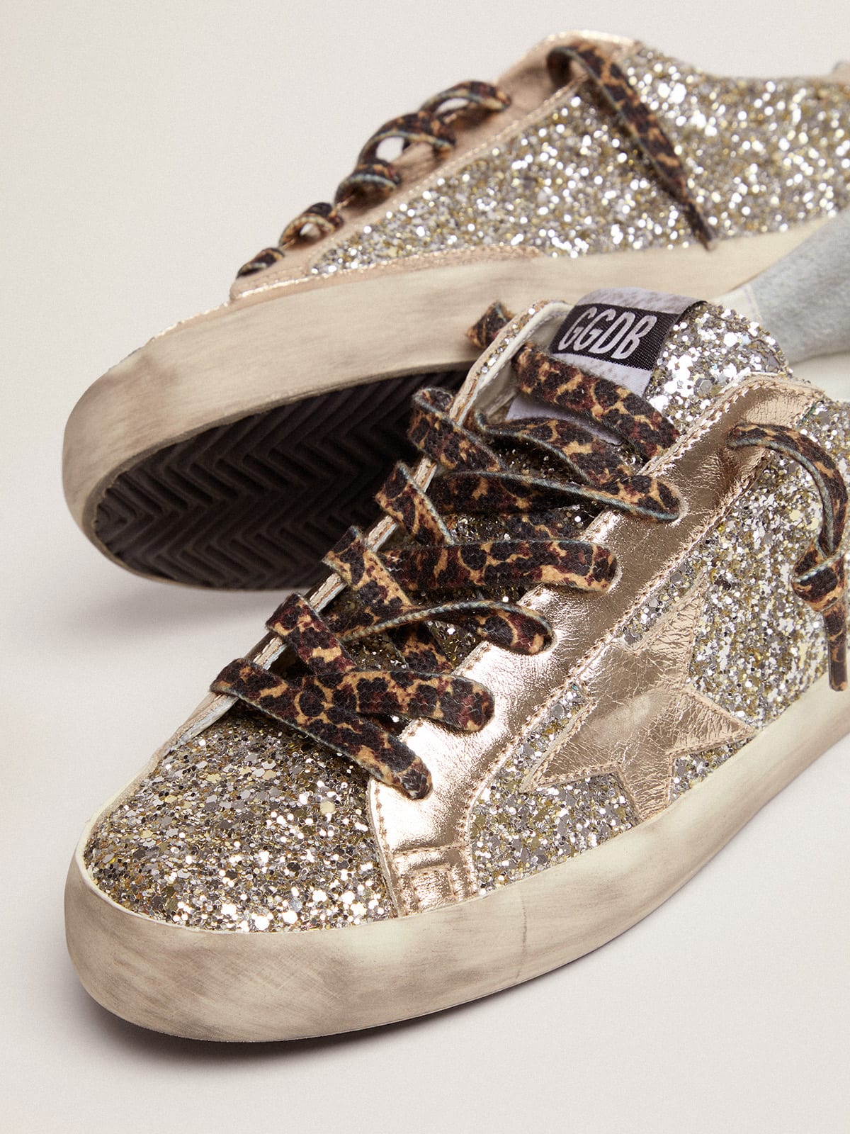 Sneaker Super-Star in glitter color platino con stella e talloncino in pelle laminata ton sur ton